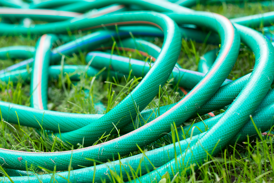 A Green And Orange Hose For Watering The Garden: A green and orange hose for watering the garden close up